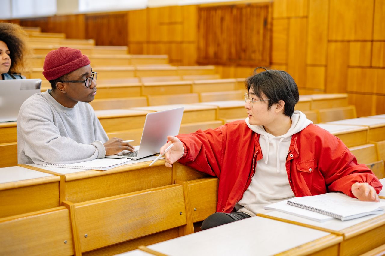 University students discussing during a class in a lecture hall.